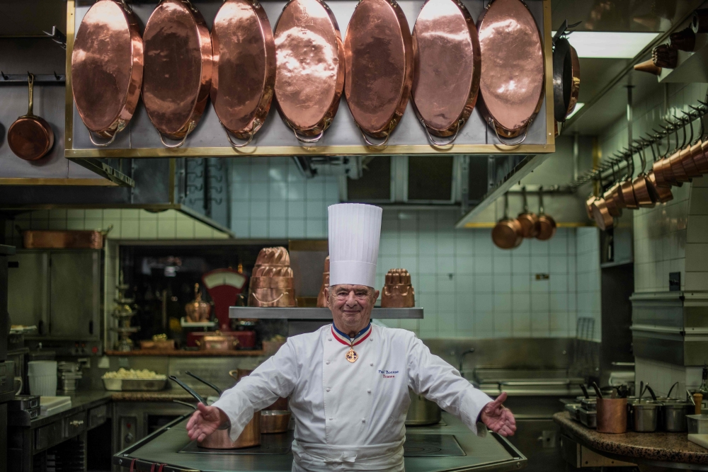 In this file photo taken on November 9, 2012 French chef Paul Bocuse, at Collonges au Mont d'Or, works in l'Aubergede Pont de Collonges kitchen, during a culinary work shop, in Mont d'Or. / AFP / JEFF PACHOUD