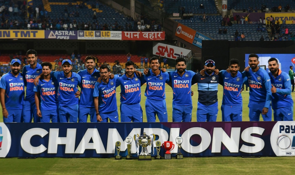 India's cricketers pose for a team photograph with the trophy after winning the third and last one day international (ODI) cricket match of a three-match series between India and Australia at the M. Chinnaswamy Stadium in Bangalore on January 19, 2020. / 