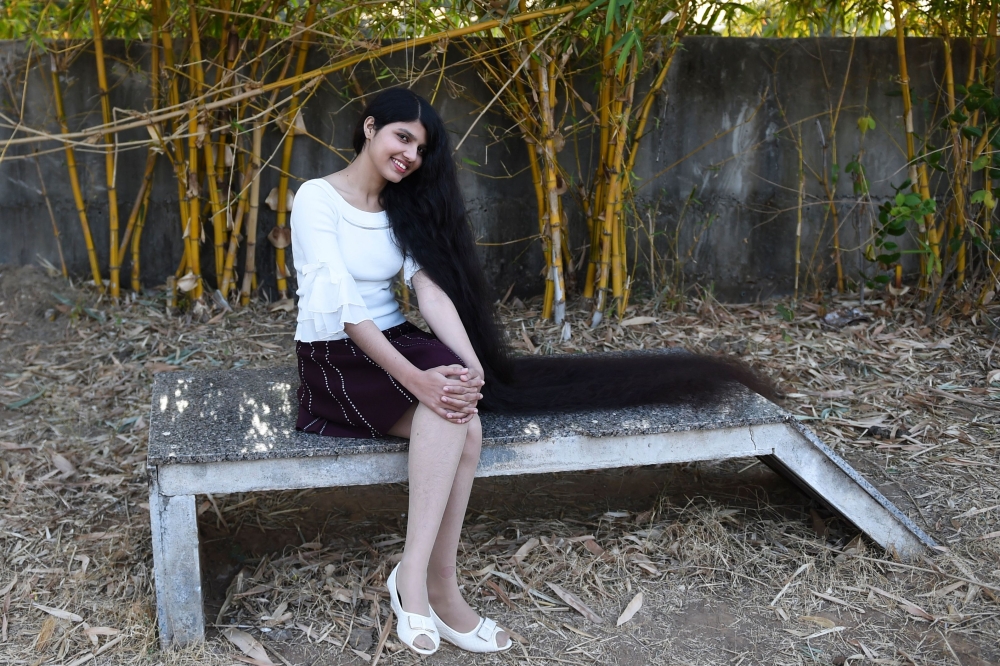 Nilanshi Patel, 17, who has been awarded the 2019 Guinness World Record for the longest hair in the teenager category, 190 cm, poses for a picture at Modasa town, some 110 Kms from Ahmedabad on January 19, 2020. AFP / SAM PANTHAKY