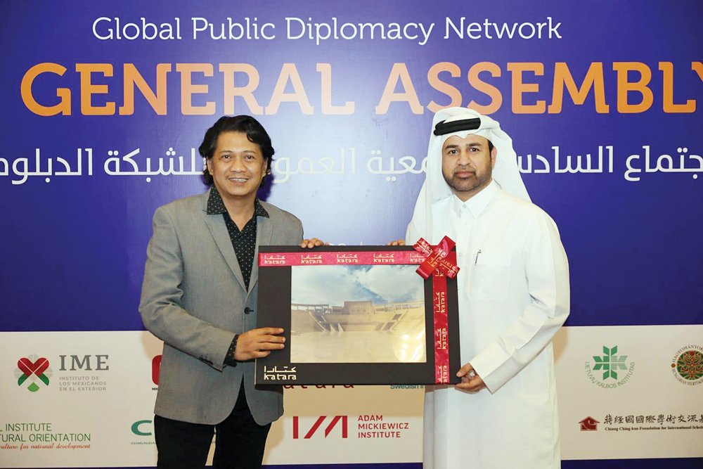 Dr. Khalid bin Ibrahim Al Sulaiti, General Manager of Katara and the President of the Global Public Diplomacy Network, honouring one of the participants.