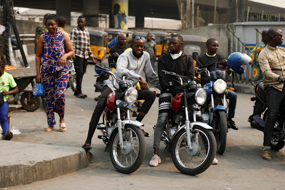  Motorcycle taxi drivers sit on their bikes, popularly called 