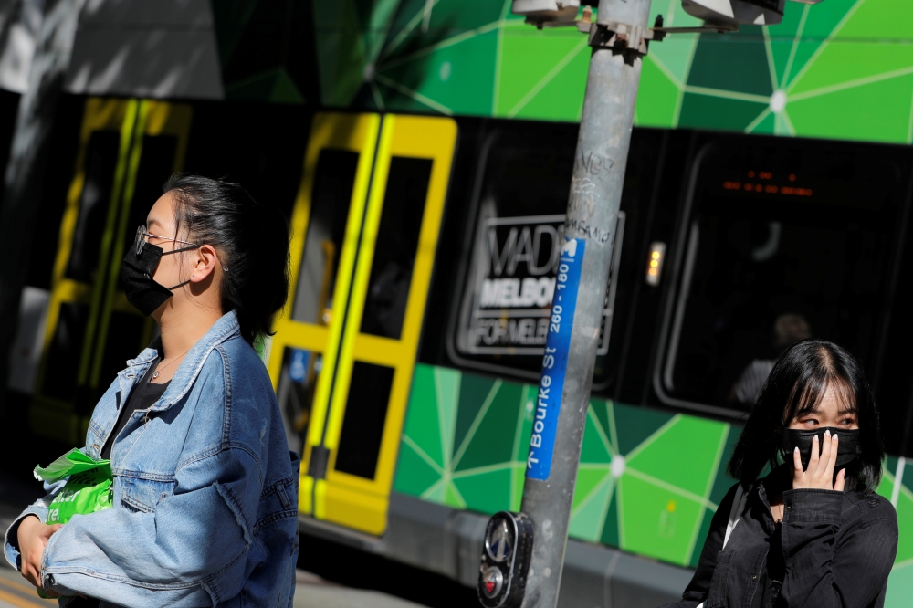  People wearing face masks walk on Bourke Street after cases of the coronavirus were confirmed in Melbourne, Victoria, Australia, January 29, 2020. REUTERS/Andrew Kelly 