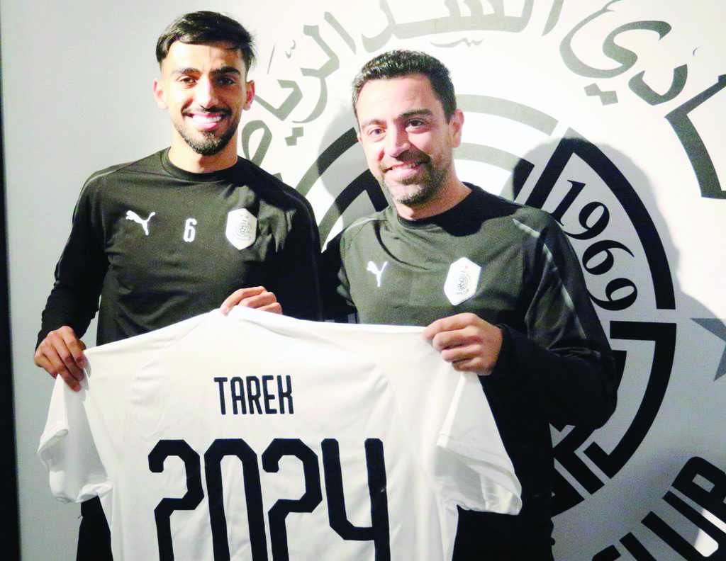 Al Sadd's defender Tareq Salman holds a team jersey with coach Xavi Hernandez at the Al Sadd Club yesterday after the club announced that the Qatari international's contract has been extended until the 2024 season.