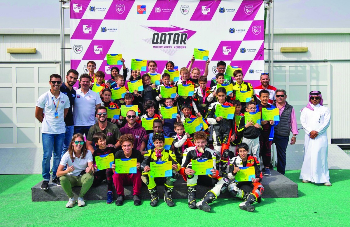 Riders and officials pose for a group photo.