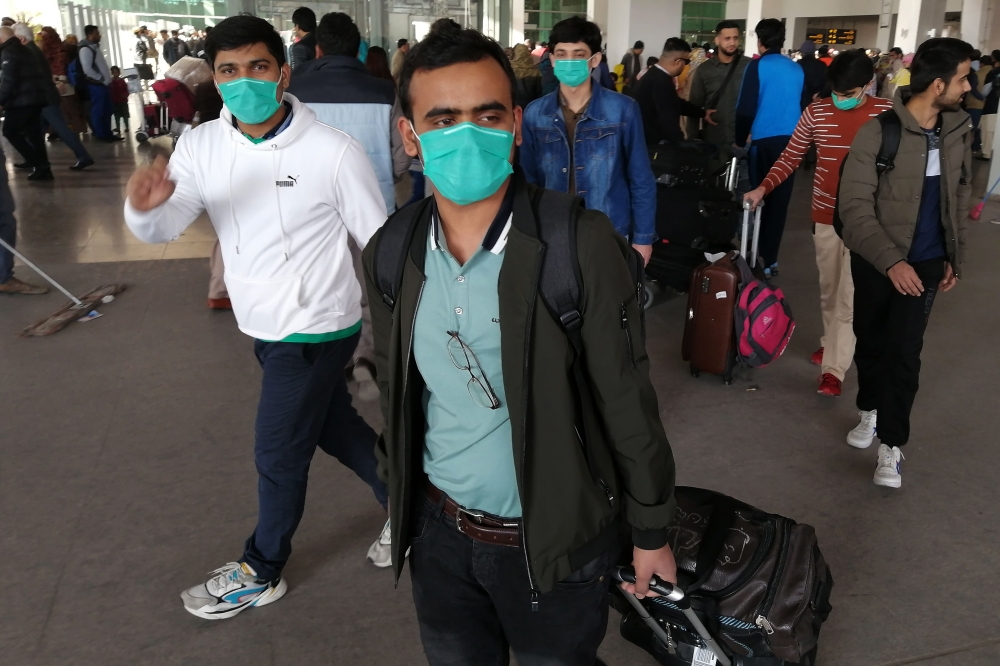 Pakistani students wearing protective facemasks come out upon their arrival from China at the Islamabad International Airport in Islamabad on February 3, 2020./ AFP / Aamir QURESHI
