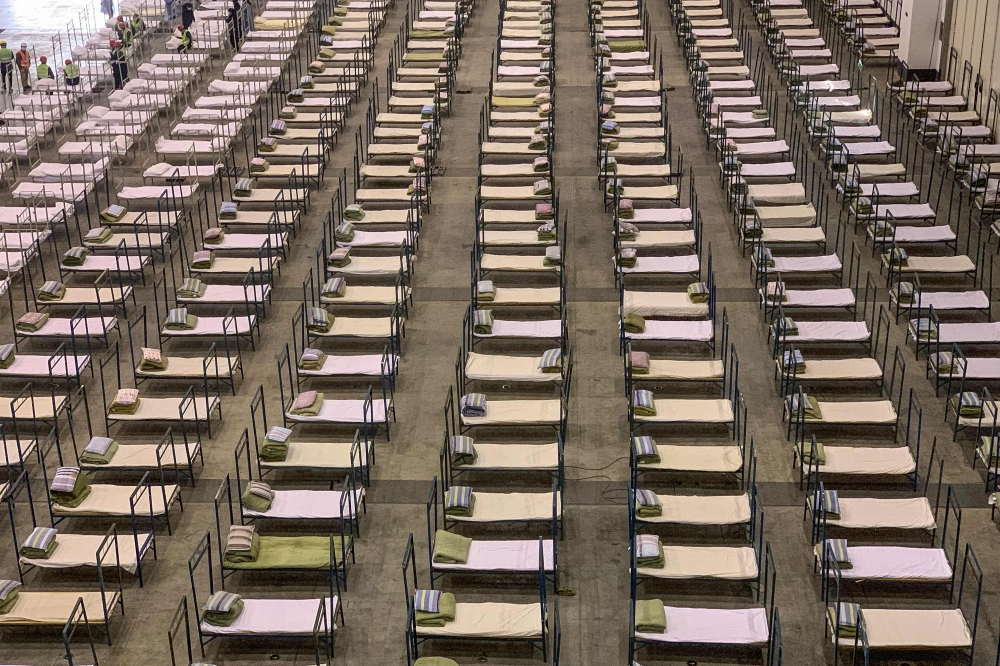 Workers set up beds at an exhibition centre that was converted into a hospital in Wuhan in China's central Hubei province on February 4, 2020. AFP