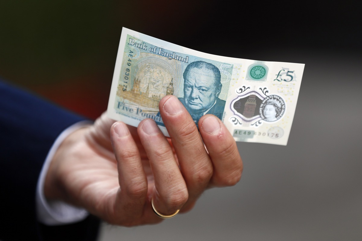 FILE PHOTO: Bank of England governor Mark Carney poses with a new polymer five pound note at Whitecross Street Market in London September 13, 2016. Reuters / Stefan Wermuth
