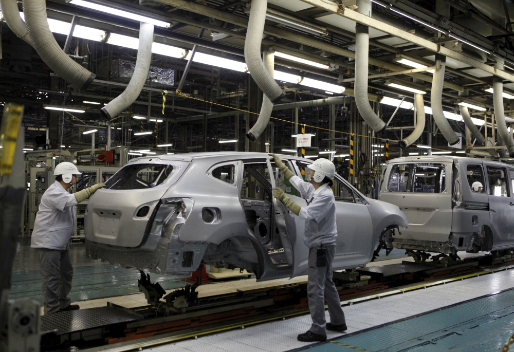 FILE PHOTO: Employees of Nissan Motor Co. work on the assembly line at the company's Kyushu plant in Kanda town, Fukuoka Prefecture, Japan, July 9, 2015. Picture taken July 9, 2015. REUTERS/Maki Shiraki