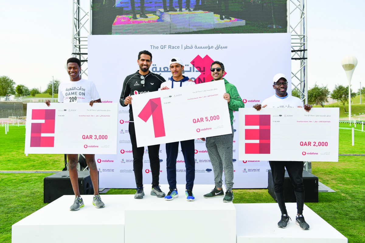 Vodafone Qatar’s brand ambassador, Mohammed Saadon Al Kuwari (second left), hands prizes to Qatar Foundation’s Obstacle winners, which was held as part of the National Sport Day celebrations.
