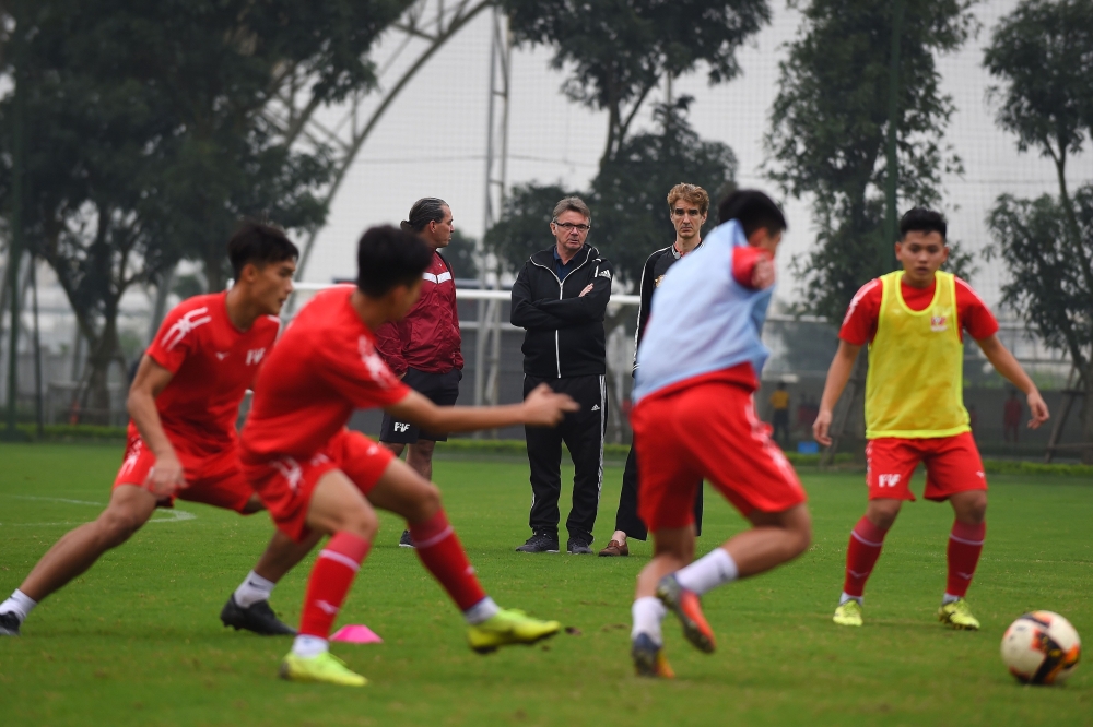 This photograph taken on January 13, 2020, shows former French football player and technical director of the Promotion Fund of Vietnamese Football Talent (PVF) academy Philippe Troussier (C) watching players during a training session at the PVF academy in