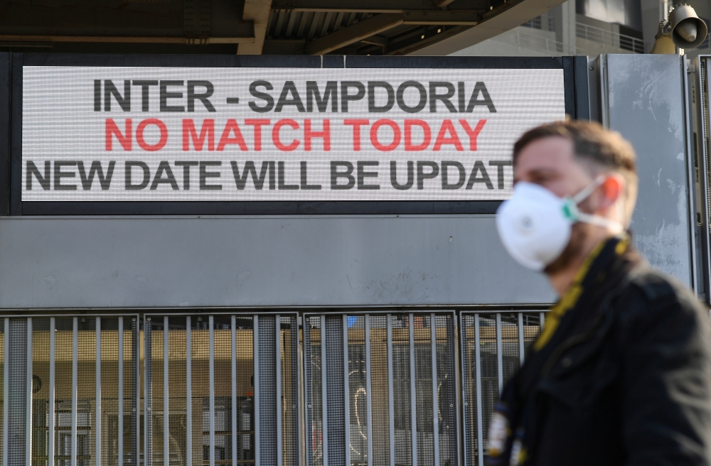 A man wearing mask stands outside the San Siro stadium after Serie A match was cancelled due to  the coronavirus outbreak in Lombardy and Veneto in Milan, Italy, February 23, 2020. Reuters / Daniele Mascolo
