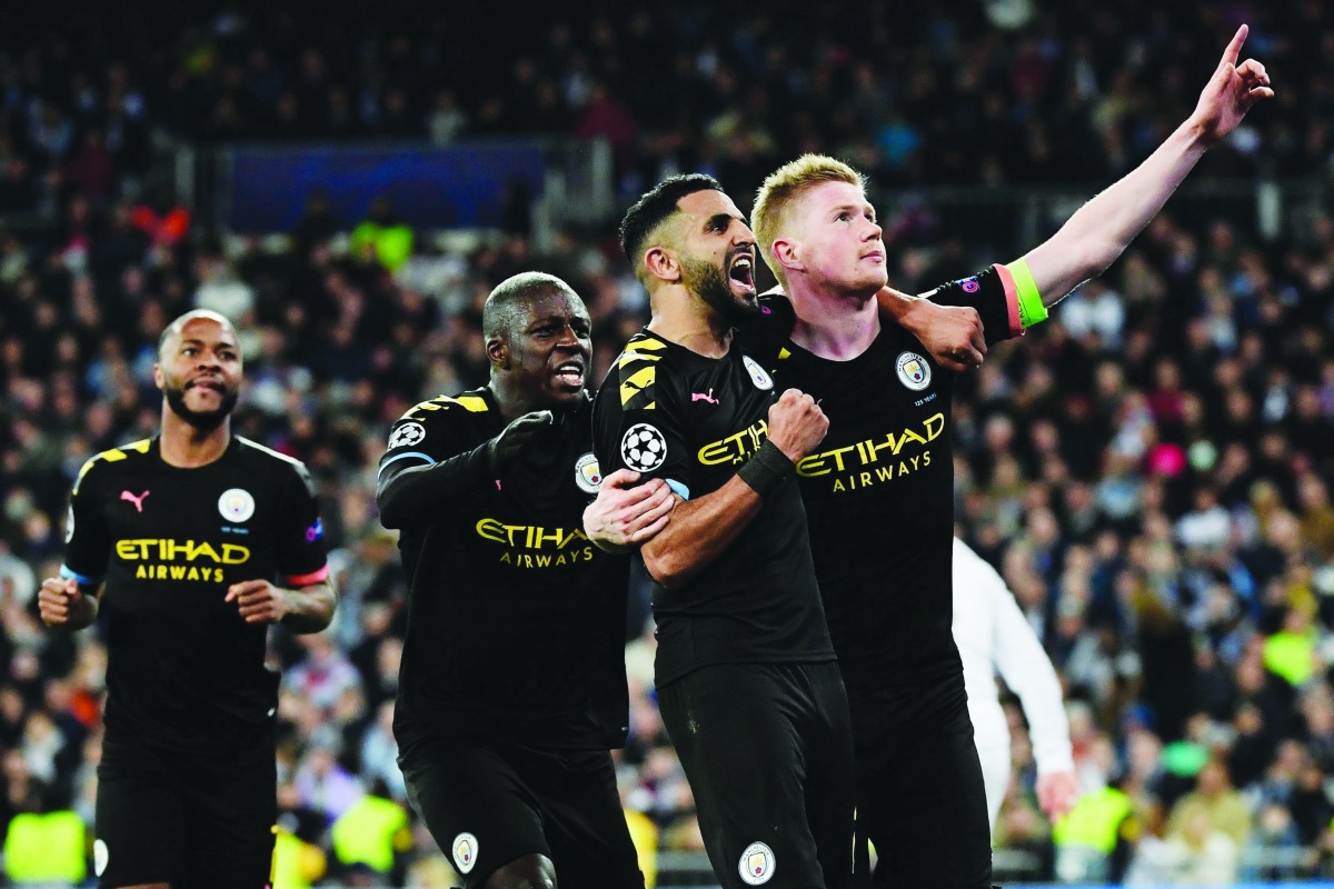 Manchester City's Belgian midfielder Kevin De Bruyne (R) celebrates his goal with teammates during the UEFA Champions League round of 16 first-leg football match between Real Madrid CF and Manchester City at the Santiago Bernabeu stadium in Madrid on Febr