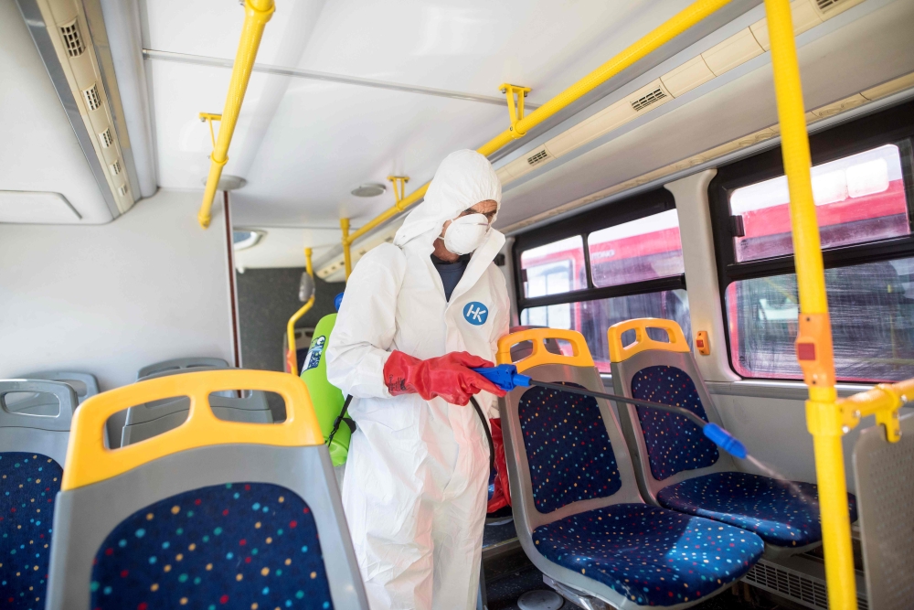 A worker disinfects a public bus against COVID-19, the novel coronavirus, in Skopje on February 29, 2020.  AFP / Robert ATANASOVSKI