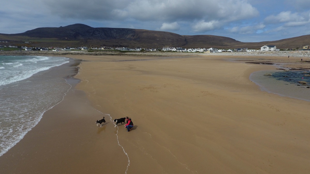 A woman walks her dogs along Dooagh beach, Achill island County, Mayo, Ireland, May 5, 2017.  Sean Molloy / Achill Tourism via Reuters