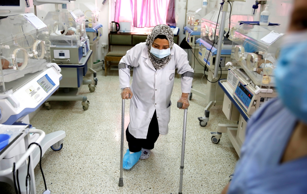 A nurse with a broken leg works in a room where premature babies are under control in incubators at a maternity hospital in Idlib, Syria February 27, 2020. Reuters/Umit Bektas