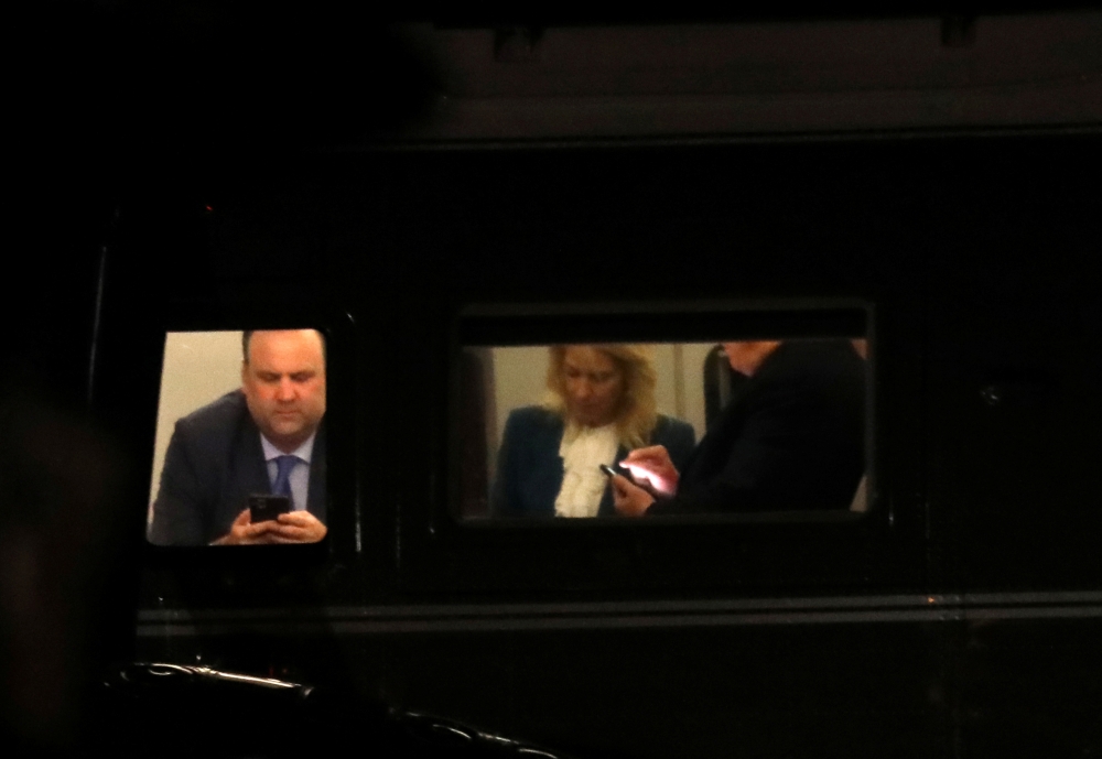 US President Donald Trump, his social media director, Dan Scavino (L), and senior adviser Kellyanne Conway look at their phones together on Marine One on their way back to the White House after returning from Pennsylvania to Joint Base Andrews in Maryland