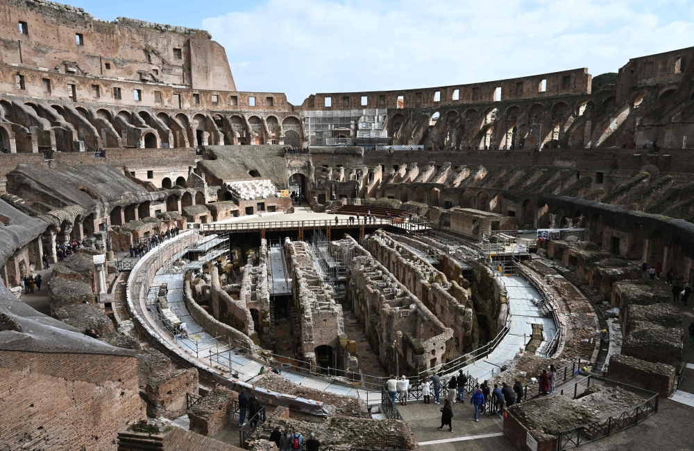 Tourists, some of them wearing respiratory masks, visit the Coliseum in Rome on March 6, 2020.  AFP / Tiziana Fabi 