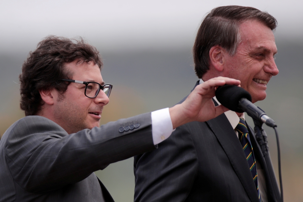 Chief of the Secretariat of Social Communication Fabio Wajngarten mutes the microphone for Brazil's President Jair Bolsonaro, during a Flag Day ceremony at the Alvorada Palace, in Brasilia, Brazil November 19, 2019. Reuters/Ueslei Marcelino