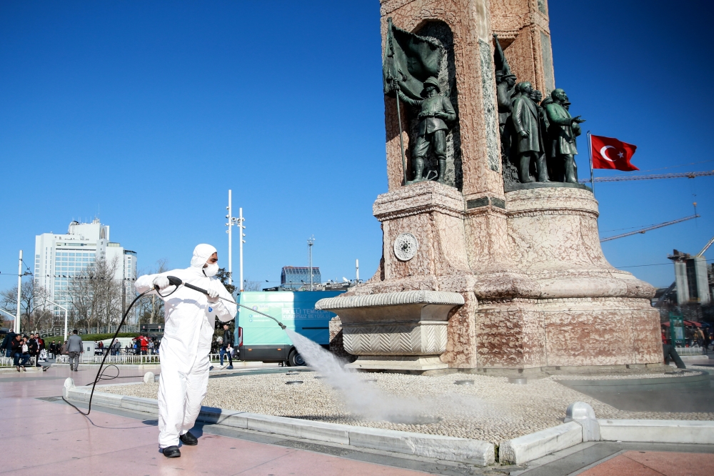  ISTANBUL, TURKEY - MARCH 12: A member of health official, wearing a protective suit, disinfects Taksim Square and Istiklal Street as a precaution to Coronavirus (Covid-19) in Istanbul, Turkey on March 12, 2020. ( Ahmet Bolat - Anadolu Agency ) 