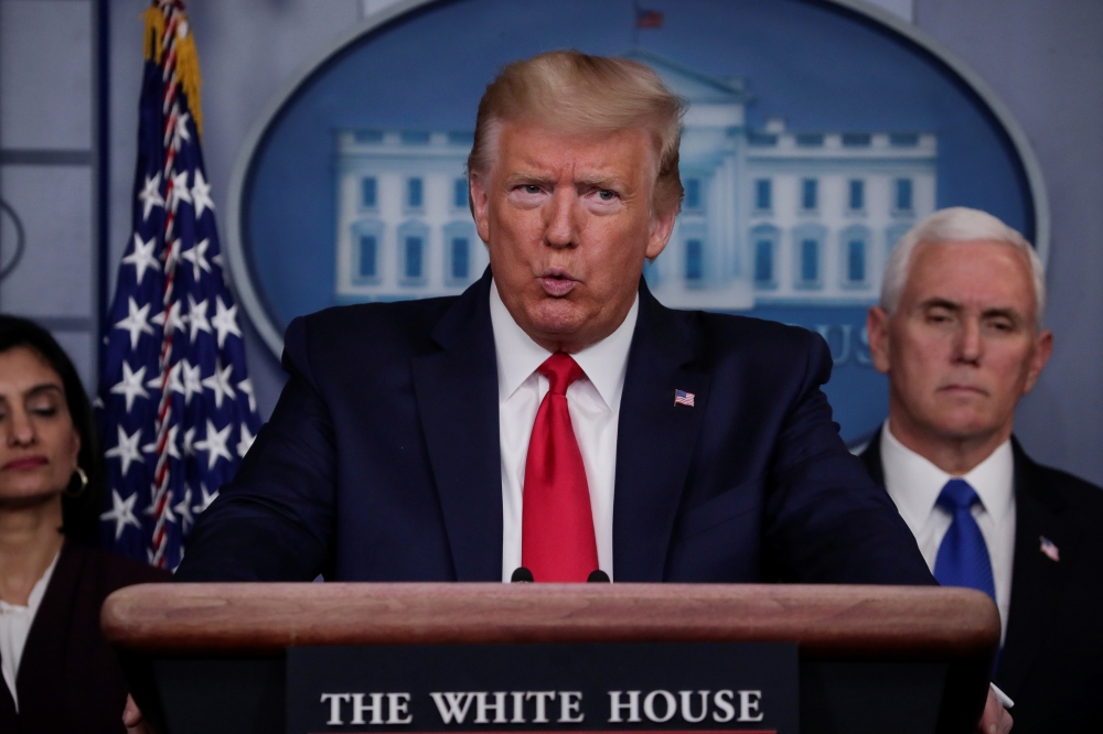 U.S. President Donald Trump addresses the daily coronavirus response briefing as Seema Verma, administrator of the Centers for Medicare & Medicaid Services, and Vice President Mike Pence look on at the White House in Washington, U.S., March 18, 2020. REUT