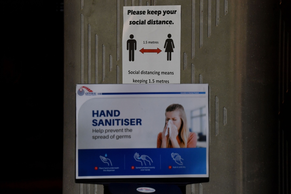 A sign reminding people of social distancing hangs inside a food court where restaurants are closed in Sydney on March 25, 2020, due to restrictions to stop the spread of the worldwide COVID-19 coronavirus outbreak. / AFP / Saeed KHAN