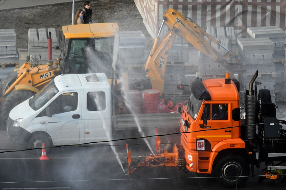 A municipal vehicle disinfects a street on the outskirts of Moscow on March 28, 2020, as the city attempts to curb the spread of the COVID-19, the disease caused by the novel coronavirus. / AFP / Kirill KUDRYAVTSEV