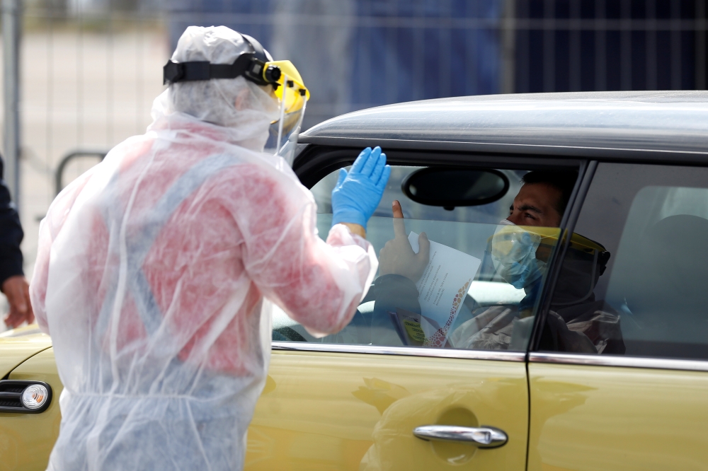 A health worker at a drive-thru coronavirus disease (COVID-19) testing center in Lisbon, Portugal, March 26, 2020. REUTERS/Rafael Marchante