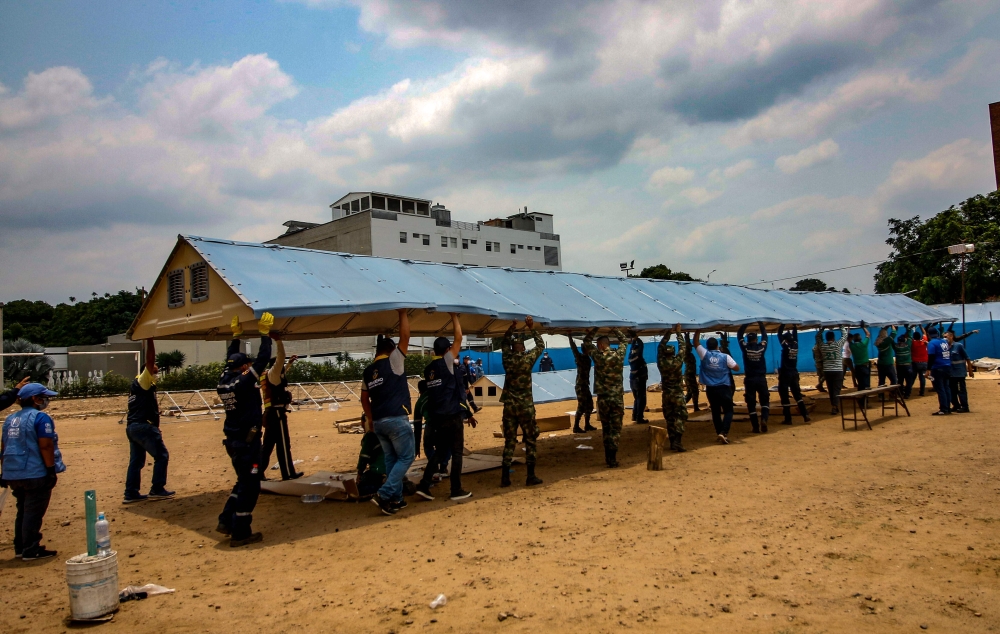 UNHCR workers setting up a temporary hospital to care for those infected with the COVID-19, in Cucuta, Colombia, on the border with Venezuela, on March 28, 2020. AFP / Schneyder Mendoza 
 