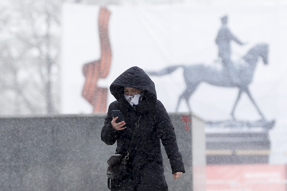 MOSCOW, RUSSIA - MARCH 31: A woman wearing a medical mask during a snowfall at Red square after preventive measures against the coronavirus (Covid-19) are taken in Moscow, Russia on March 31, 2020. ( Sefa Karacan - Anadolu Agency )