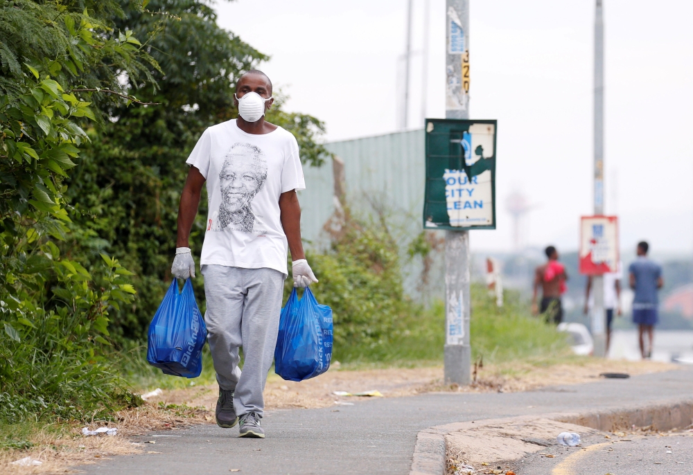 FILE PHOTO: A man carries home groceries during a nationwide 21 day lockdown in an attempt to contain the coronavirus disease (COVID-19) outbreak in Umlazi township near Durban, South Africa, March 31, 2020. REUTERS/Rogan Ward