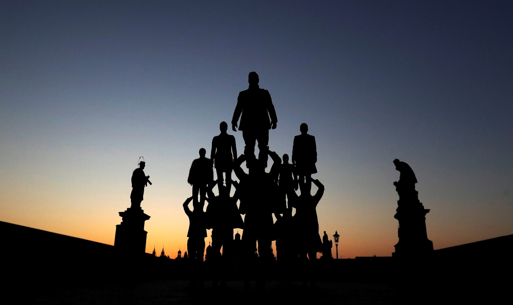 Street artists perform on the medieval Charles Bridge during sunrise as the spread of the coronavirus disease (COVID-19) continues in Prague, Czech Republic, April 2, 2020. REUTERS/David W Cerny