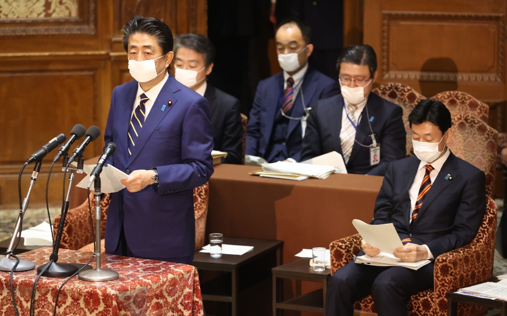 Japan's Prime Minister Shinzo Abe (front L) delivers a report to committee members of the Lower House in Tokyo on April 7, 2020 before declaring a state of emergency due to the COVID-19 coronavirus. Japan OUT / AFP / JIJI PRESS / STR