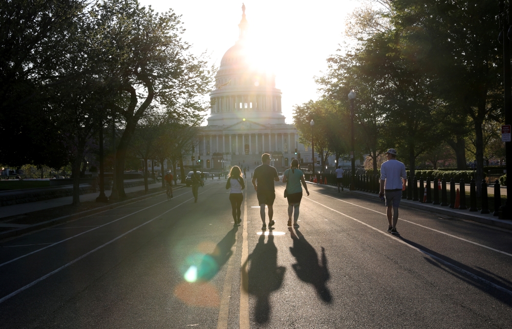 People take advantage of minimal traffic as they run, walk, jog and cycle down East Capitol Street towards the U.S. Capitol building as the spread of coronavirus disease (COVID-19) continues in Washington, U.S., April 6, 2020. REUTERS/Leah Millis
