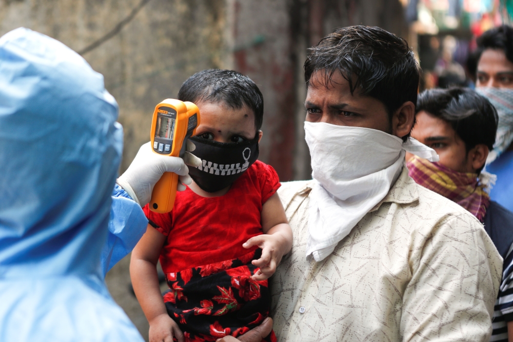 A doctor scans residents from Dharavi, one of Asia's largest slums, with an infrared thermometer to check their temperature as a precautionary measure against the spread of the coronavirus disease (COVID-19), in Mumbai, India, April 11, 2020. REUTERS/Fran