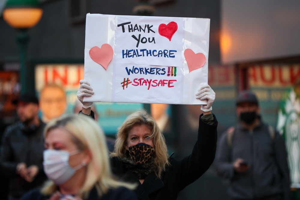 :NEW YORK, USA - APRIL 12: A woman holds a 'Thank You' sign for healthcare workers who risk their lives to serve for new type of coronavirus (COVID-19) patients in New York City, United States on April 12, 2020. ( Tayfun Co?kun - Anadolu Agency )
