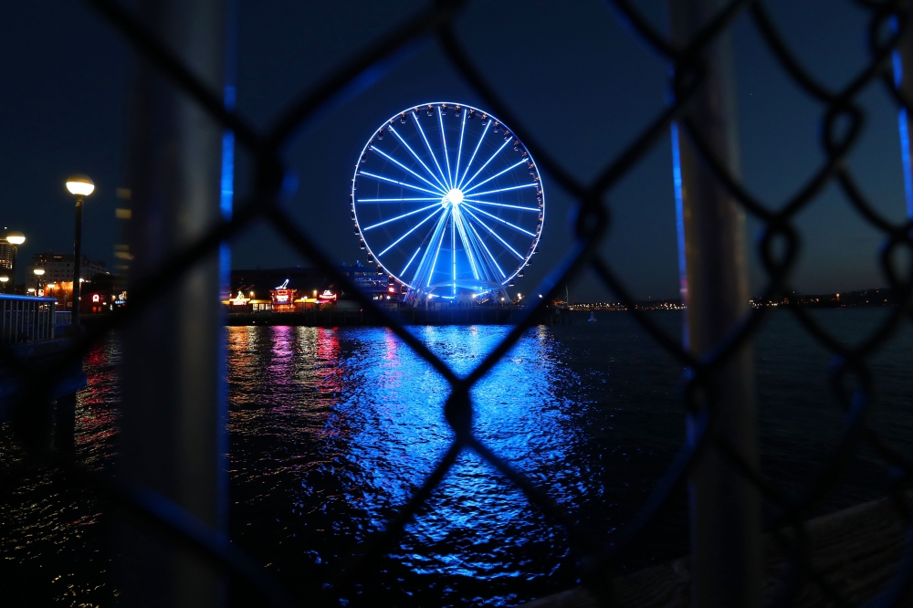 Seattle, WA - APRIL 9: A general view of The Seattle Great Wheel lit up in blue to honor essential workers during the coronavirus (COVID-19) outbreak on April 09, 2020 in Seattle, Washington.  Abbie Parr/AFP
