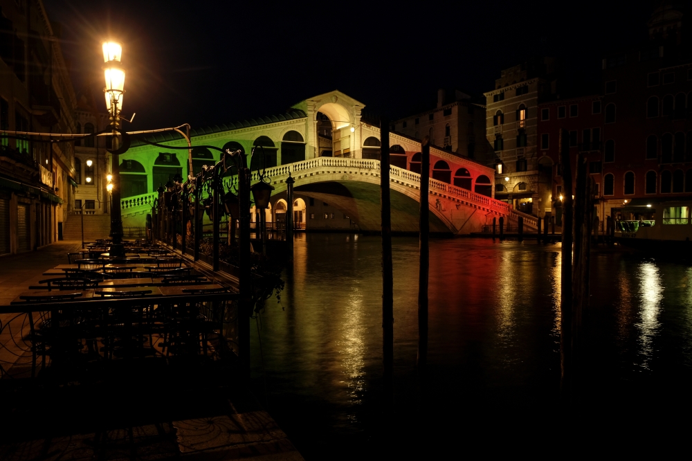 Rialto bridge lights up with the colours of the Italian flag in solidarity with the citizens as the spread of the coronavirus disease (COVID-19) continues in Venice, Italy April 16, 2020 REUTERS/Manuel Silvestri