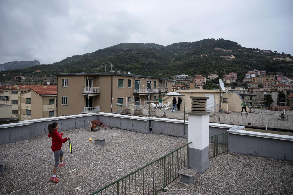 Carola Pessina (foreground) plays tennis with Vittoria Oliveri on the rooftops of their house in Finale Ligure, Liguria Region, northwestern Italy on April 19, 2020, during the country's lockdown aimed at stopping the spread of the COVID-19 (new coronavir