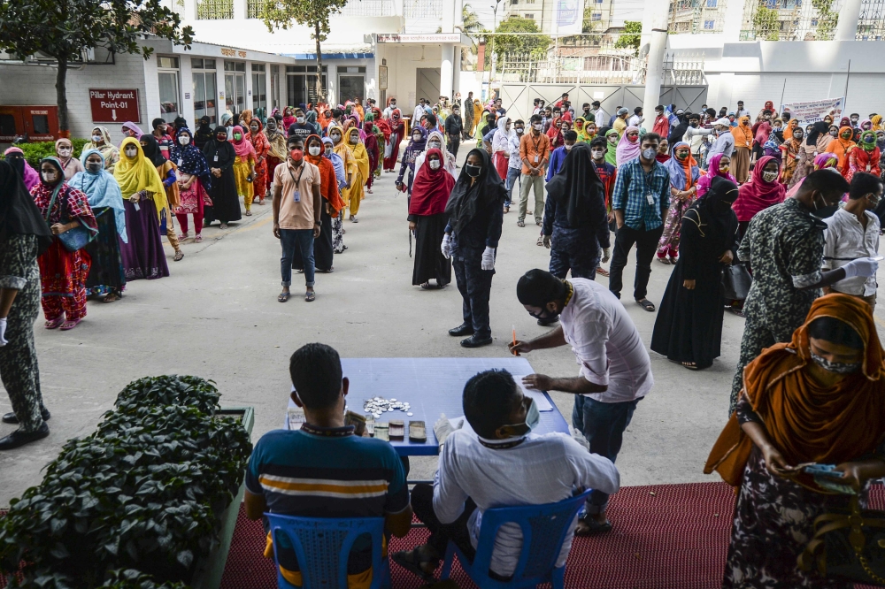  In this file photo taken on April 7, 2020, labourers wait in queues to collect their salary in a garment factory during a government-imposed lockdown as a preventive measure against the COVID-19 coronavirus in Savar, on the outskirts of Dhaka. (AFP / MUN