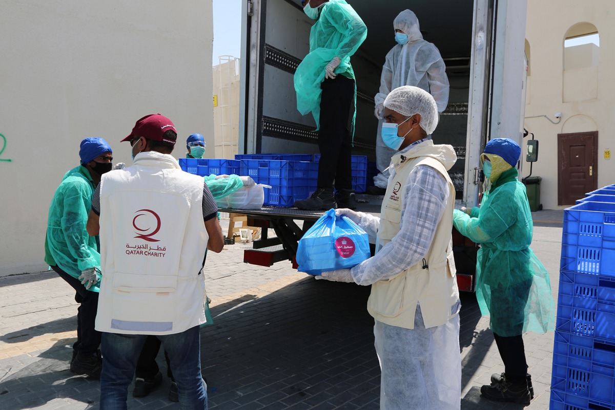 Qatar Charity officials distributing Iftar meals to workers under Ramadan campaign “Calm Your Heart by Giving”. 
