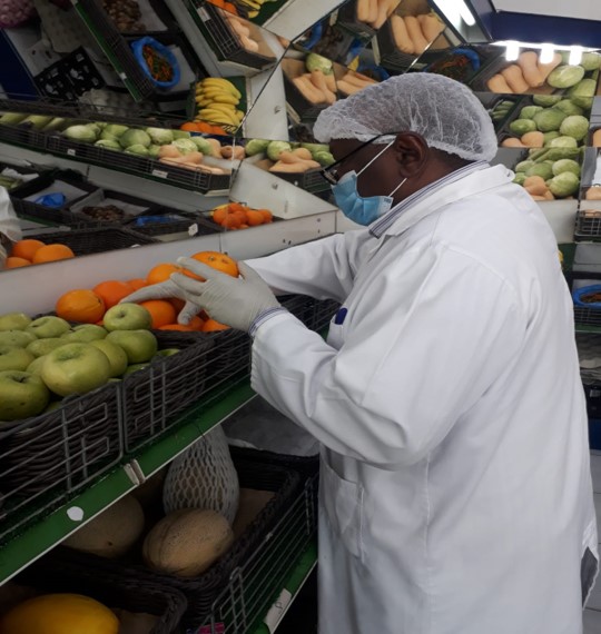 An inspector of the municipality examining the quality of vegetables at an outlet. 