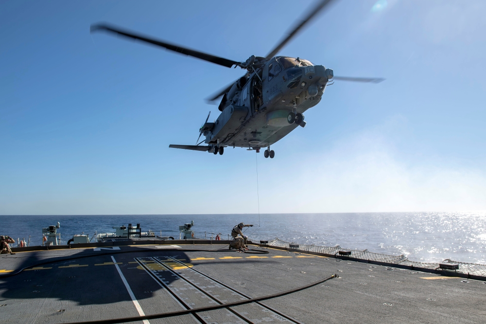 FILE PHOTO: Air detachment members aboard HMCS Fredericton attach a fueling hose on the hoist cable of a CH-148 Cyclone helicopter during Operation Reassurance at sea February 15, 2020, in this picture obtained from social media. Picture taken February 15