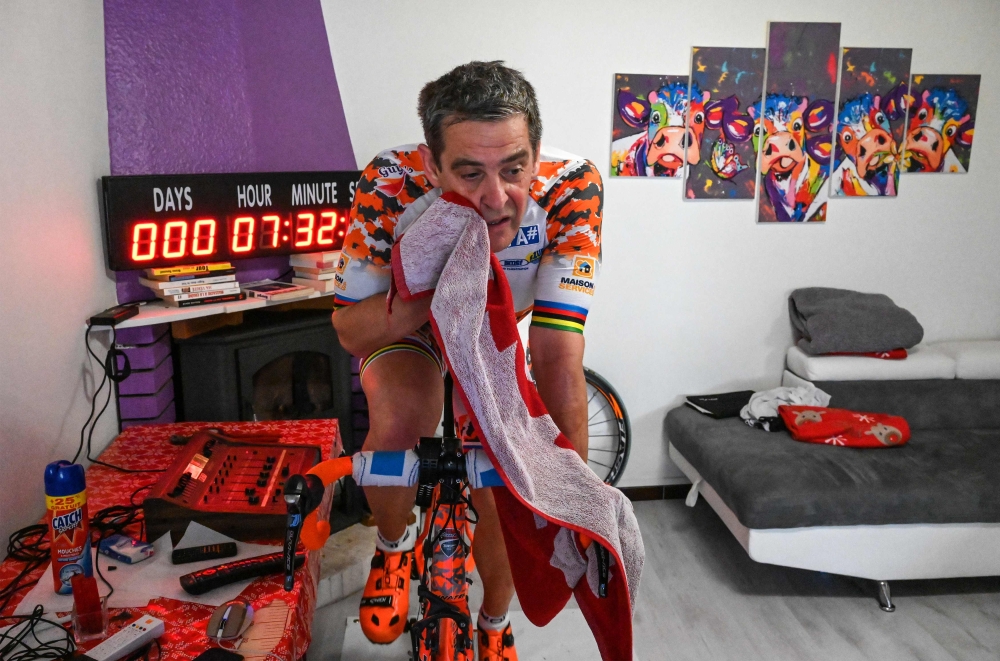 In this photograph taken on April 30, 2020, tri-athlete Pascal Pich, rides on a training bicycle in his living room in Savignargues, near Nimes in southern France. AFP / Pascal Guyot