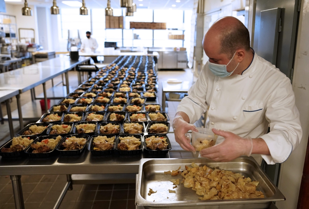 :Food is prepared by Okan Kizilbayir, Sous Chef along with Le Bernardin chef and co-owner Eric Ripert as they are preparing meals for health care workers as part of the World Central Kitchen charity at his flagship New York restaurant in New York City on 