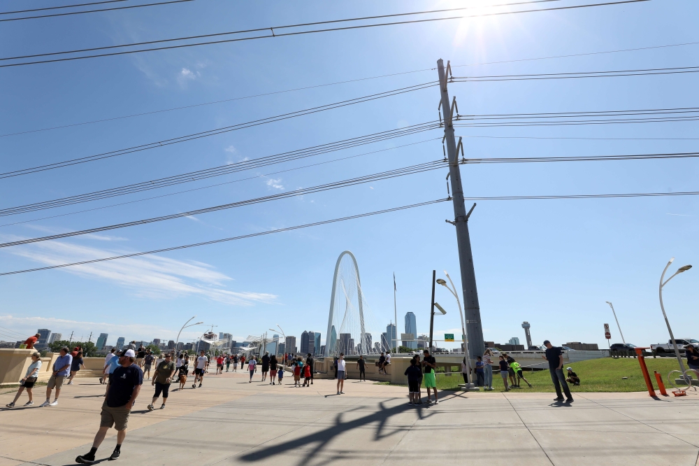 :DALLAS, TEXAS - MAY 06: People gather to watch the U.S. Navy Blue Angels flyover downtown Dallas to honor healthcare, frontline and essential workers on May 06, 2020 in Dallas, Texas. The Blue Angels performed a flyover as part of the 'America Strong' ca