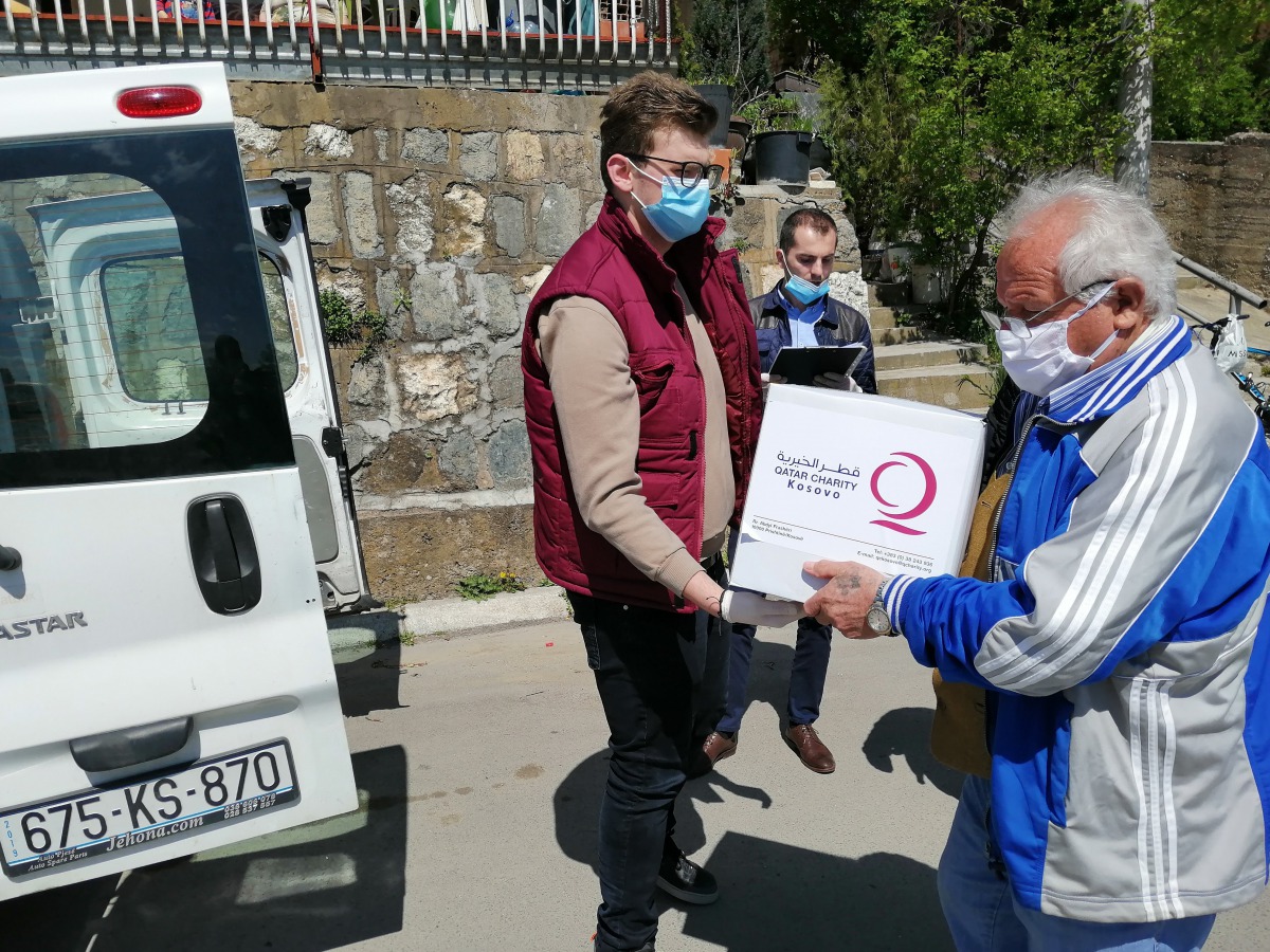 Qatar Charity officials distributing food baskets to people in need in the fight against COVID-19.