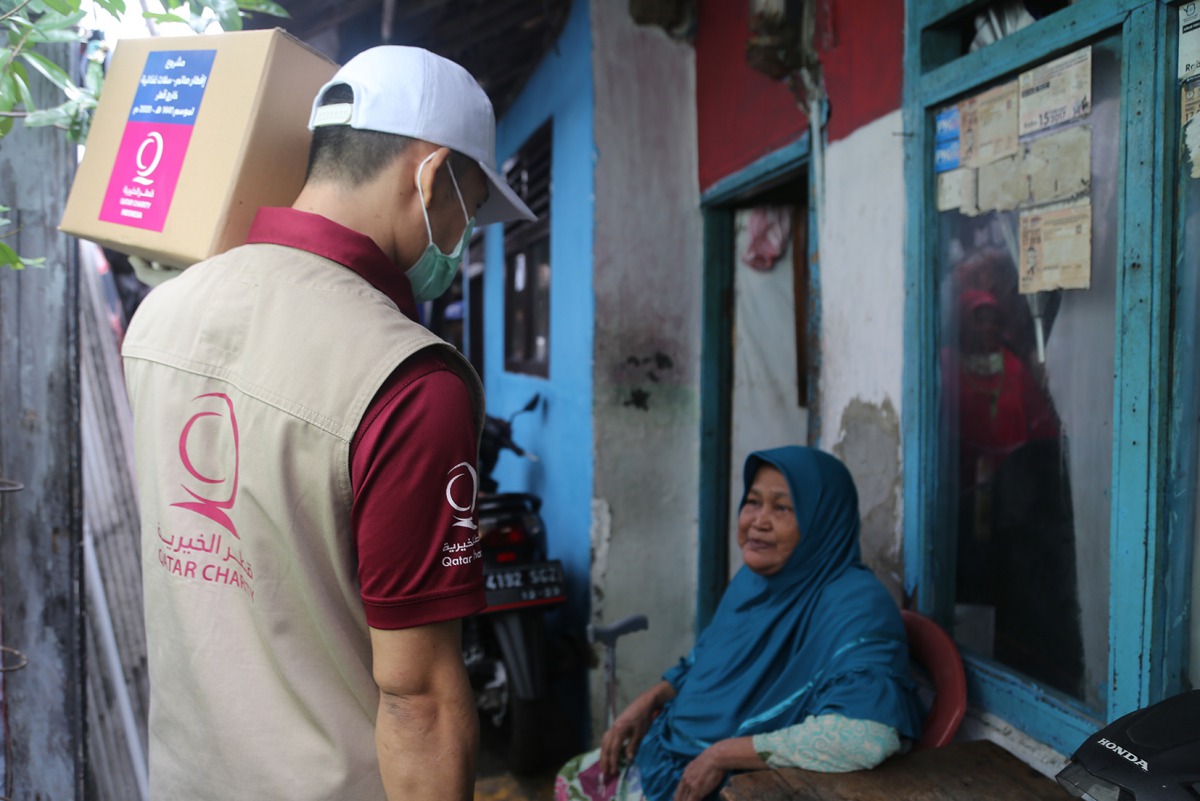 A Qatar Charity official providing aid to a beneficiary in Jakarta as part of its Ramadan campaign.