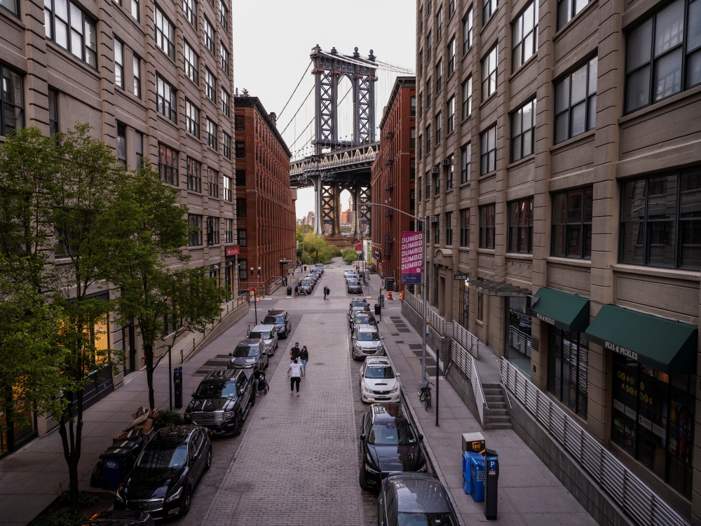 A handful of people stop on Washington Street in DUMBO neighborhood of Brooklyn with the Manhattan Bridge rising in the background as streets remain less busy due to the continuing outbreak of the coronavirus disease (COVID-19) in New York U.S., May 5, 20