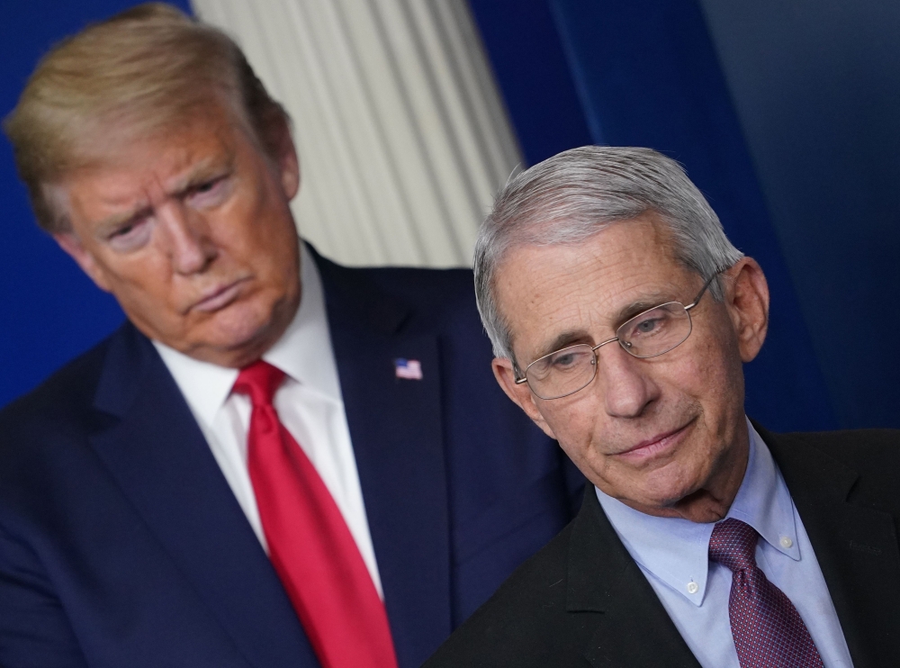 :(FILES) In this file photo Director of the National Institute of Allergy and Infectious Diseases Anthony Fauci, flanked by US President Donald Trump, speaks during the daily briefing on the novel coronavirus, which causes COVID-19, in the Brady Briefing 