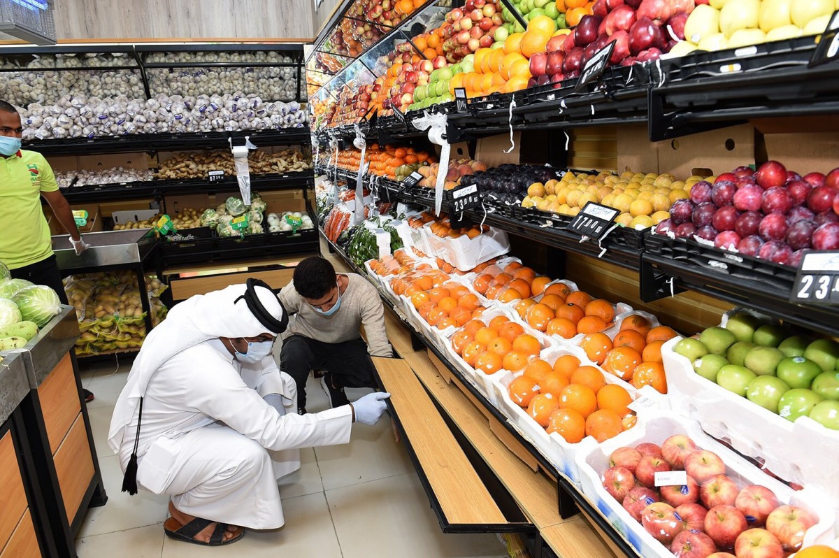 A municipal official inspects food quality and hygiene standards at a shop.